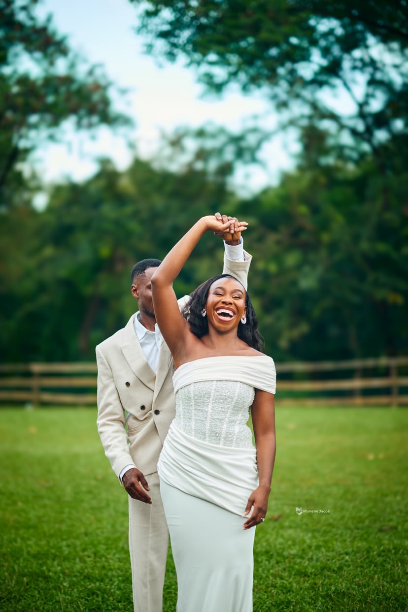A groom twirling his laughing bride on a lawn